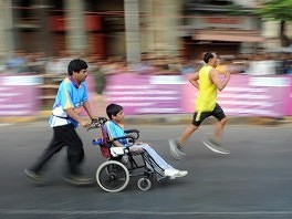 Otac gura sina u invalidskim kolicima na maratonu u Mumbaiju (Foto: AFP)