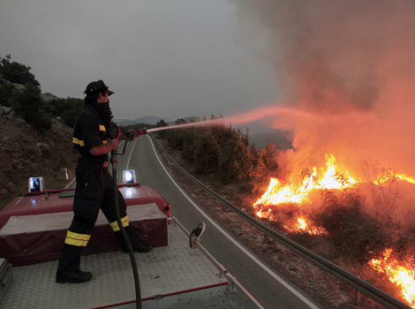 Vatrogasac u borbi sa vatrnenom stihijom u ponikvama (Foto: EPA)
