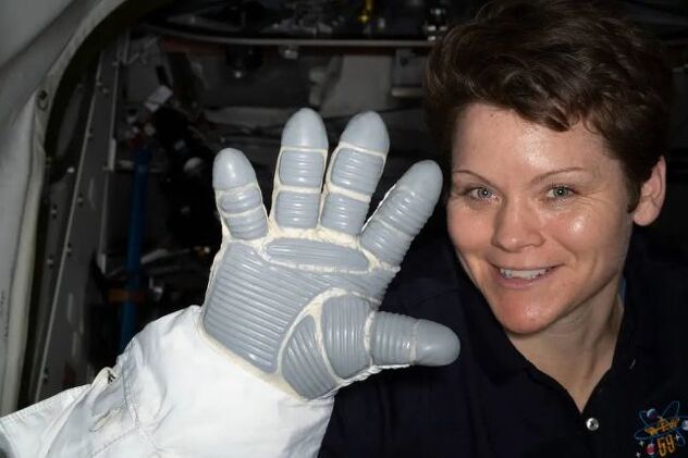 Астронаутот на НАСА Ен Меклејн покажа ракавица во вселенски костум (Фото: НАСА)