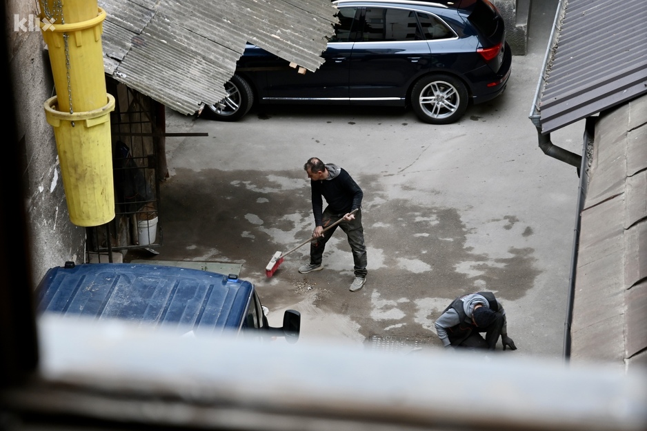 Dva radnika čiste dvorište u kojem se izvode radovi (Foto: V. D./Klix.ba)