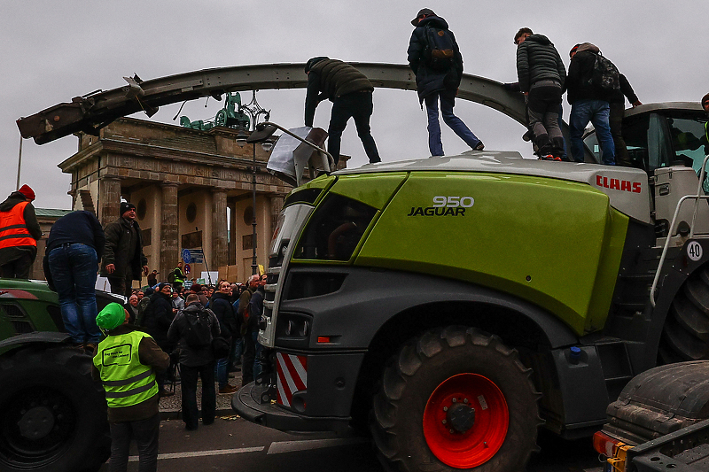 Njemački poljoprivrednici stoje na traktoru tokom protesta ispred Branderbuške kapije (Foto: EPA-EFE)