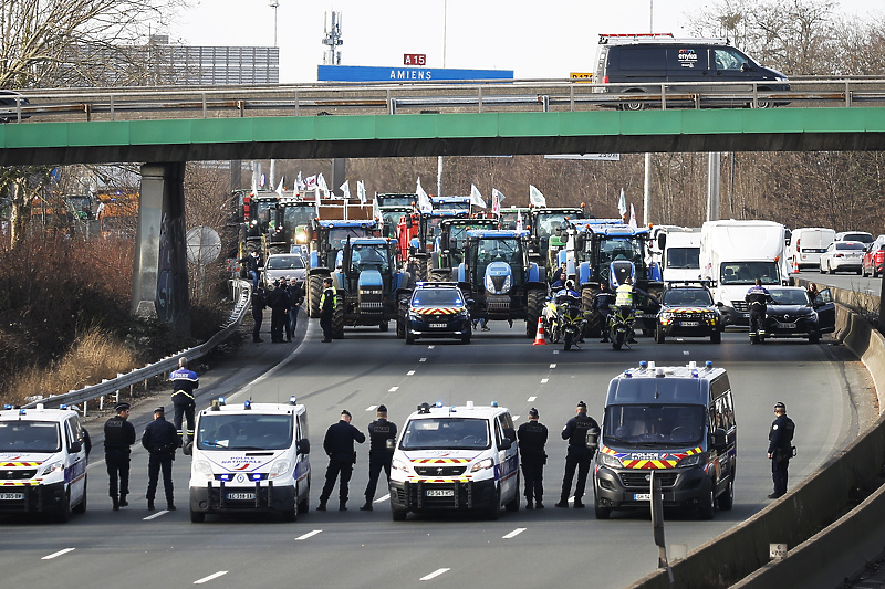 Policajci posmatraju desetine traktora koji učestvuju u demonstracijama na autoputu A15 (Foto: EPA-EFE)