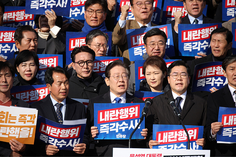 Lider glavne južnokorejske opozicione Demokratske stranke Lee Jae-myung drži natpis "Smjesta istražite njegov čin pobune" (Foto: Reuters)