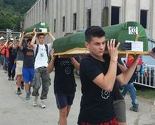 Učesnici Marša mira i porodice prebacuju tabute u musalu Memorijalnog centra u Potočarima