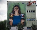Mural na zidu Ekonomske škole: Djevojka koja drži masline i "ribu borca" šalje poruku mira