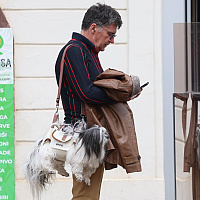 An unusual sight on the streets of Zagreb: A man carrying a dog like a fashion accessory.