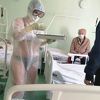 Ruska medicinska sestra u bikiniju i zaštitnom odijelu liječi pacijente
